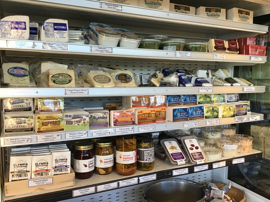 a row of blue cheeses and a row of cheddars at Rogue Creamery