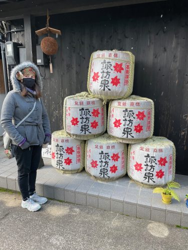 Maria with the sake barrels at Suwa Sake Brewery