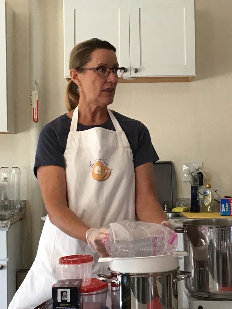 Kate placing the ziplock bag of warm water on top of the curds