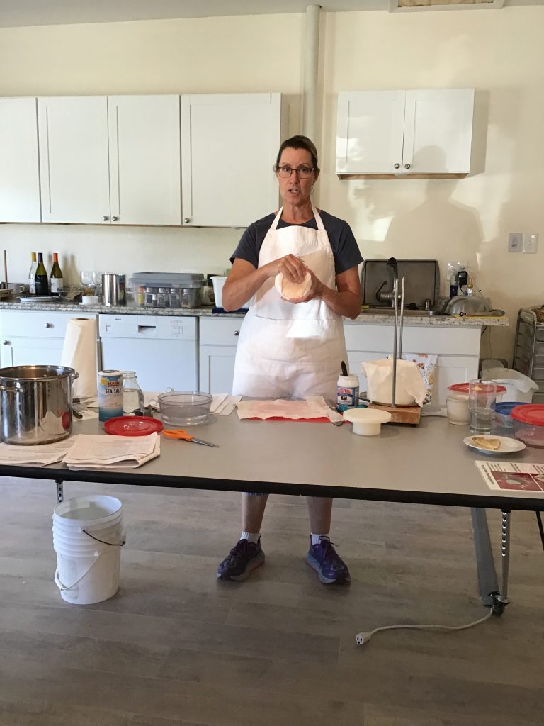 Kate showing us how to wrap the bandage around the pressed cheddar wheel