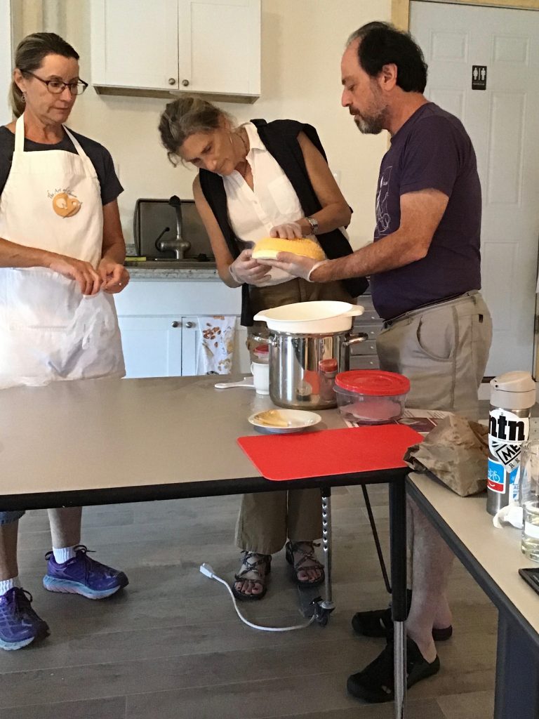 Two students in the class cheddaring the mats of all three milks while Kate observes